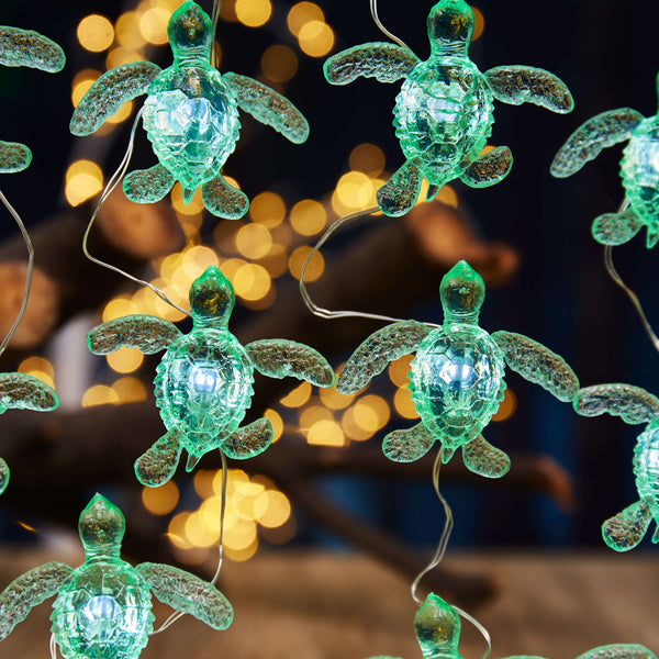 Green sea turtle string lights glowing in coastal display