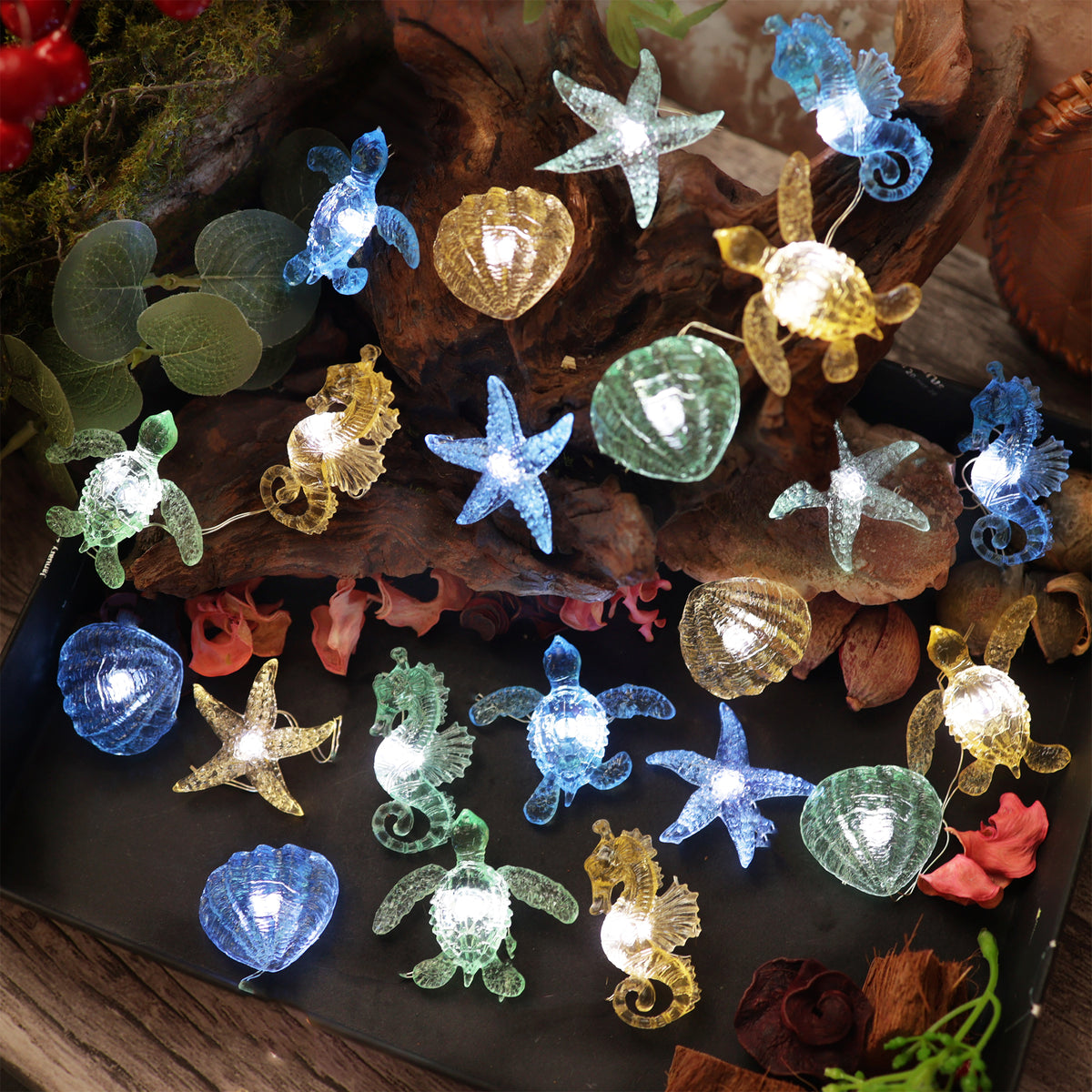 Full view of glowing Under the Sea string lights with turtles, seahorses, starfish and shells on driftwood
