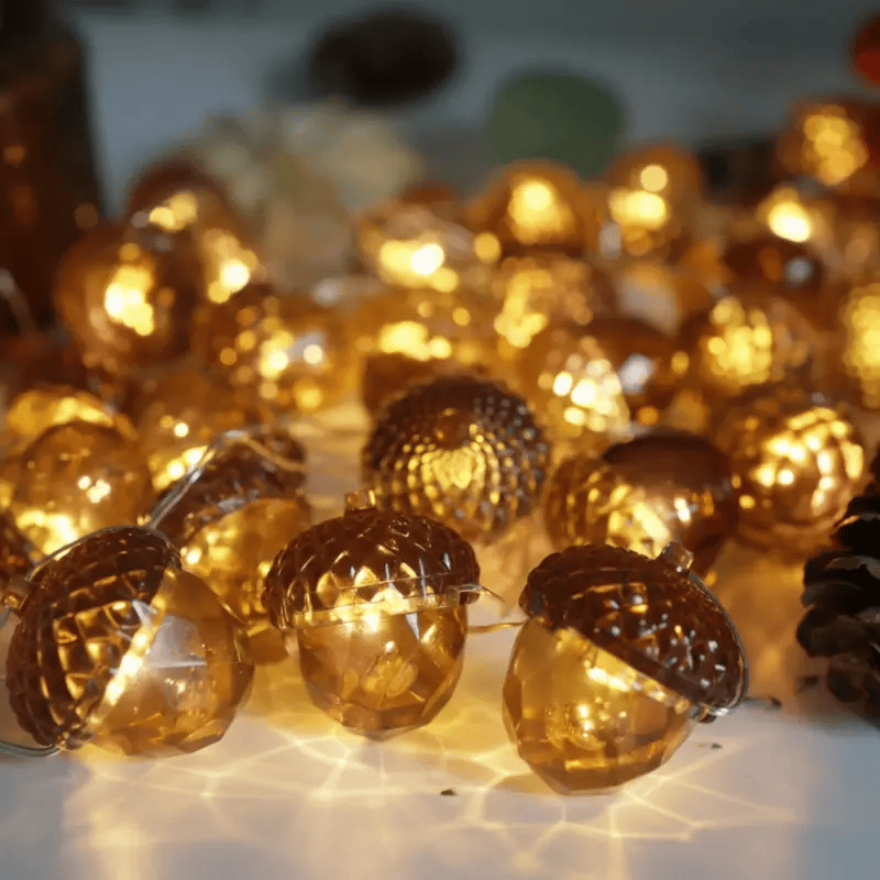 Slow rotating close-up of warm amber acorn string lights with textured brown caps on a tabletop.